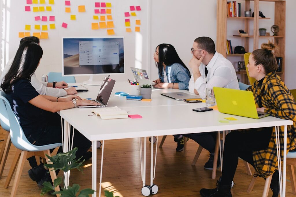 A team in an office discussing project invoicing during a meeting